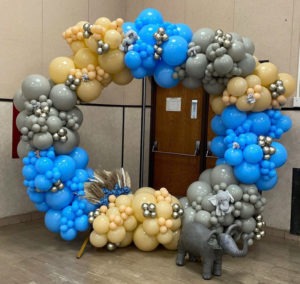 Circular balloon art in cream, blue, gray and silver balloons with an elephant theme